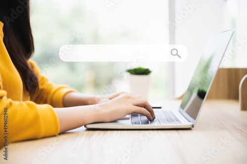 Woman using computer laptop on wood desk. She working at home