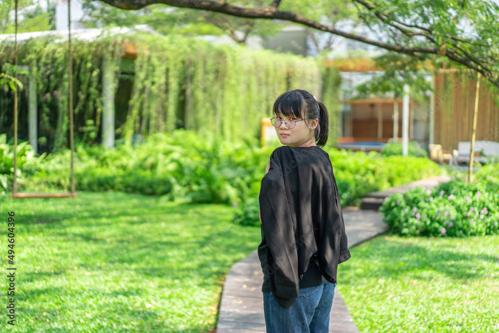 Portrait of the Asian glassese Thai woman is standing in the garden in the morning. Portrait of the Asian glassese Thai woman is standing in the garden in the morning.