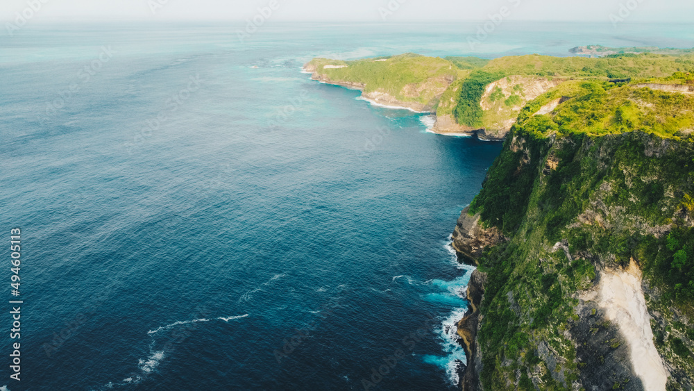 aerial view of tropical beach with high cliffs and blue sea water in the morning, Nusa Penida island Bali