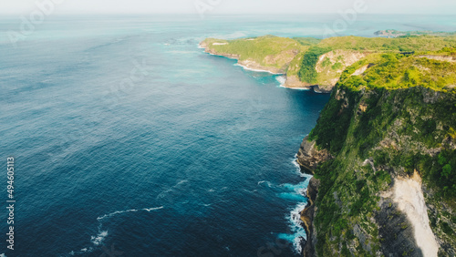 aerial view of tropical beach with high cliffs and blue sea water in the morning  Nusa Penida island Bali