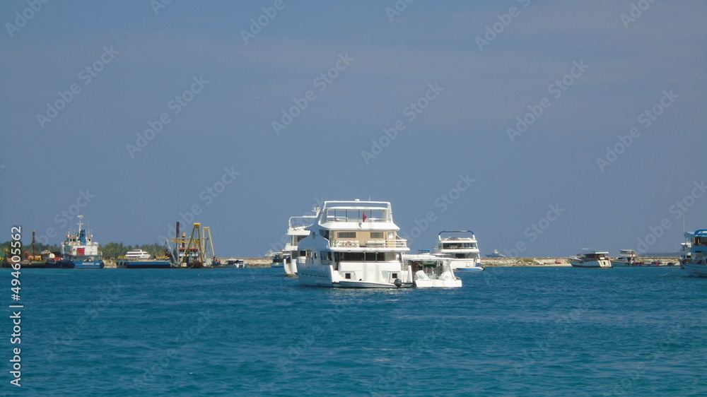 Boats and ships docked at the beautiful crystal clear water port of Male, the capital of the Maldives
