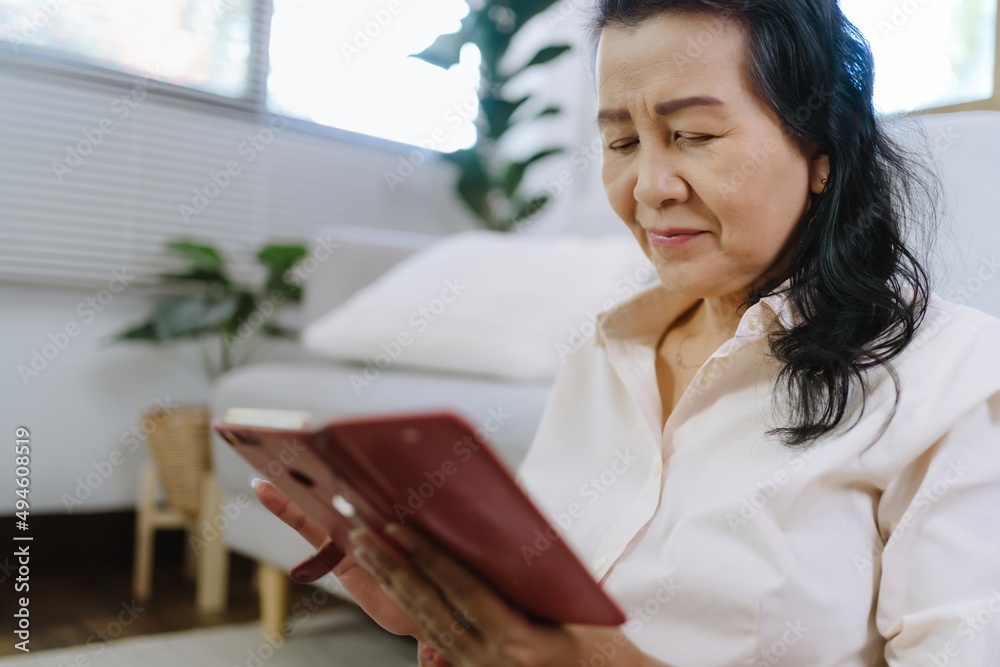 Middle age Asian woman holding cell telephone. senior woman with smart phone. elderly woman using smartphone at home with technology concept. Middle age Asian woman holding cell telephone. senior woman with smart phone. elderly woman using smartphone at home with technology concept.