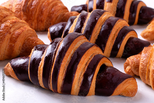 Canvastavla Croissants with chocolate made of two-colored dough on the white table
