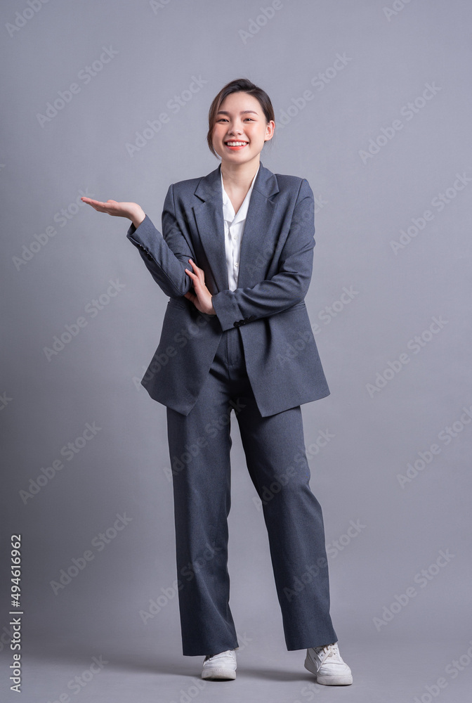 Young Asian business woman standing on gray background Young Asian business woman standing on gray background