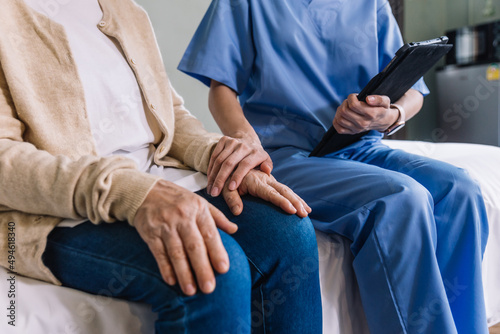 Close-up senior Asian woman hand with her caregiver helping hands, Caregiver visit at home. Home health care and nursing home concept.