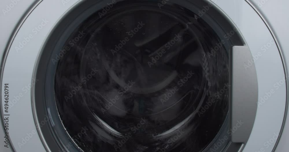 Laundry load mid-cycle wet spin drum close-up Laundry load mid-cycle wet spin drum close-up