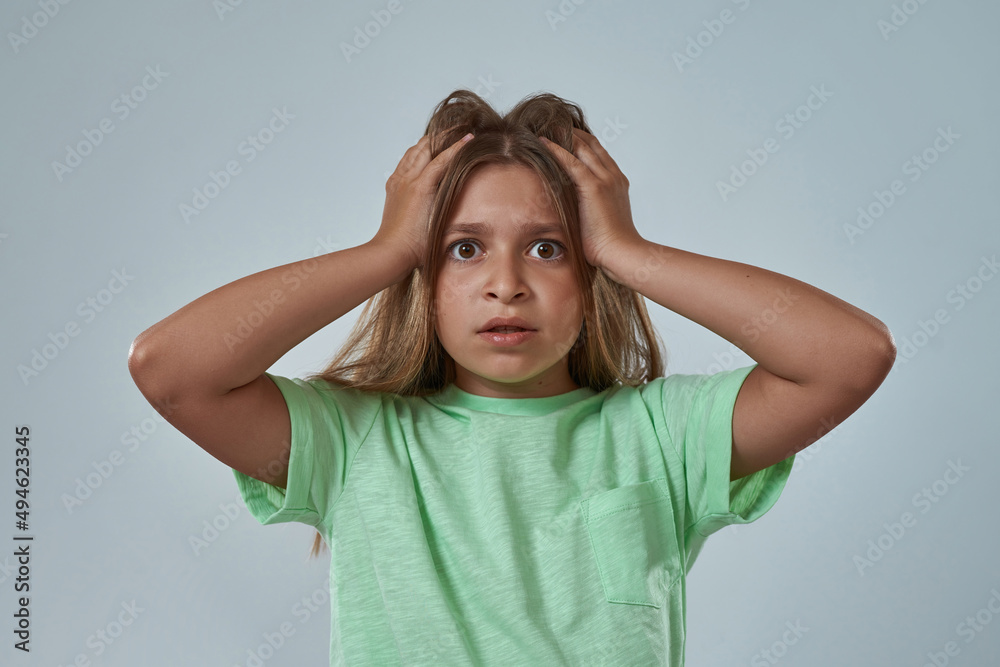 Fototapeta premium Partial of shocked little girl touching her head