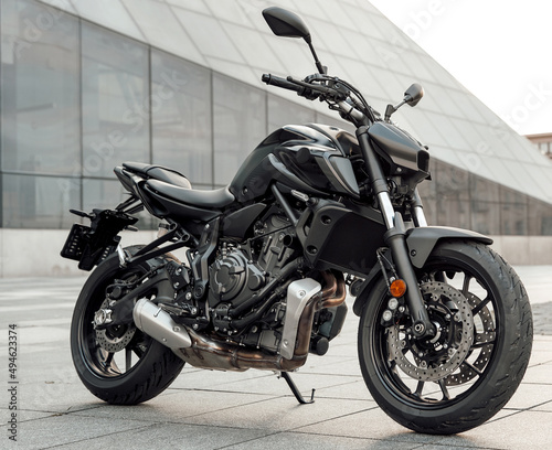 Custom black motorcycle parked outdoors in city in daytime