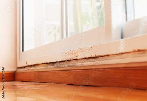 Rust on the window frame with moisture on the wall at floor level