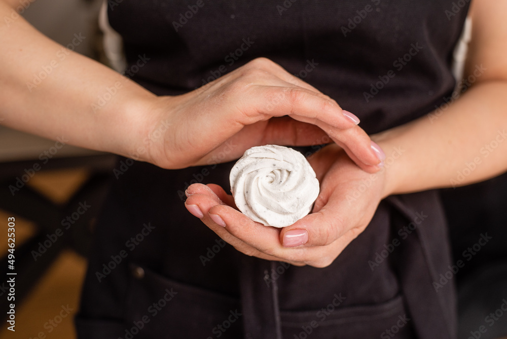 Fototapeta premium Close up of confectioner's hands holding marshmallow