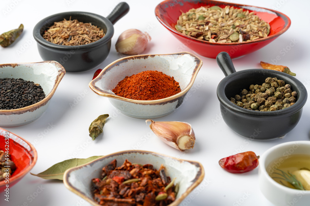 Bowls with various spices on white background