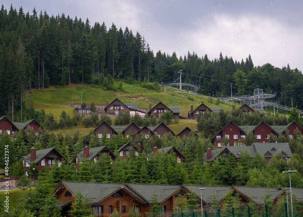 Scenic summer view of winter mountain ski resort with house cottages with forest and skiing slope in Bukovel, Ukraine. Scenic summer view of winter mountain ski resort with house cottages with forest and skiing slope in Bukovel, Ukraine.