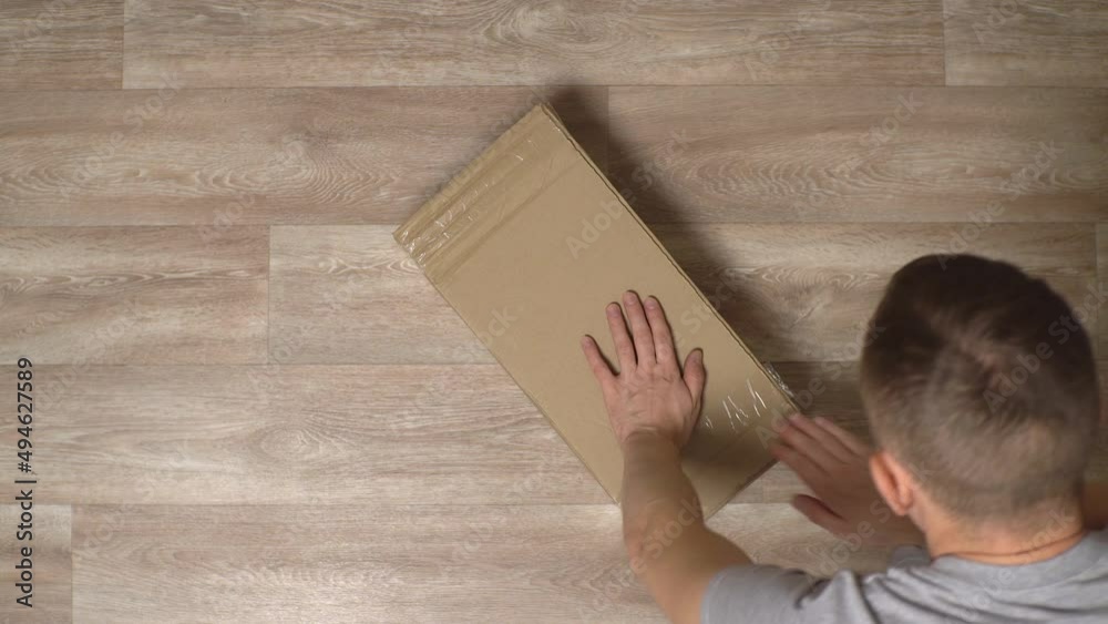 a man opens a box with spare parts for assembling furniture a man opens a box with spare parts for assembling furniture