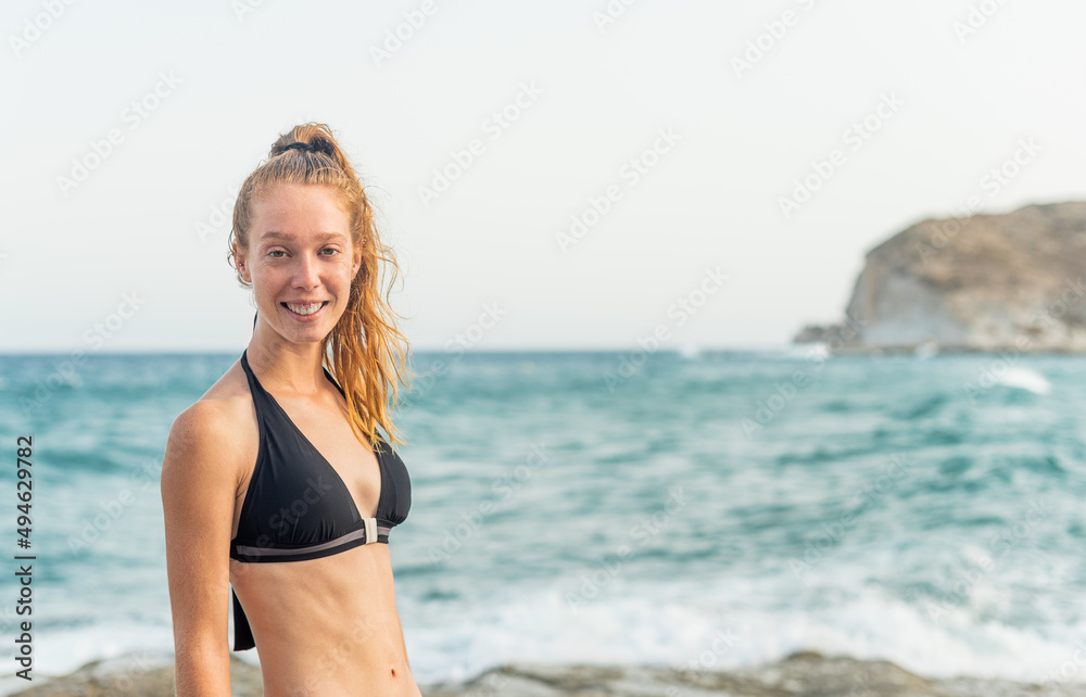 redhead girl in bikini posing in front of the sea redhead girl in bikini posing in front of the sea