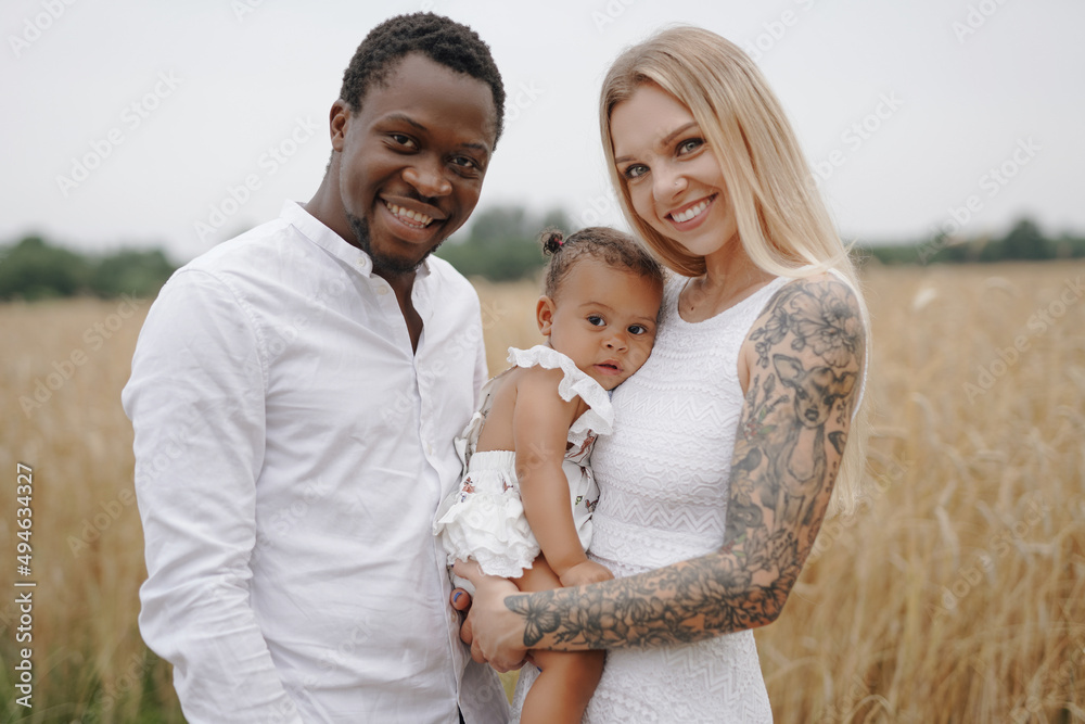 Fototapeta premium Multiethnic young family relaxing together in nature in daytime