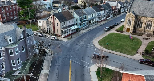 Amish horse and buggy carriage in Ephrata Lancaster County Pennsylvania. Old fashioned Plain People means of transportation. Modern vs antiquated. Aerial view crossing road intersection. photo