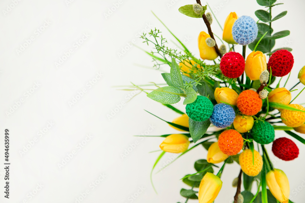 Fototapeta premium The breeze of spring. Easter composition with tulips and crocheted eggs. Featuring bouquets with handmade accents.