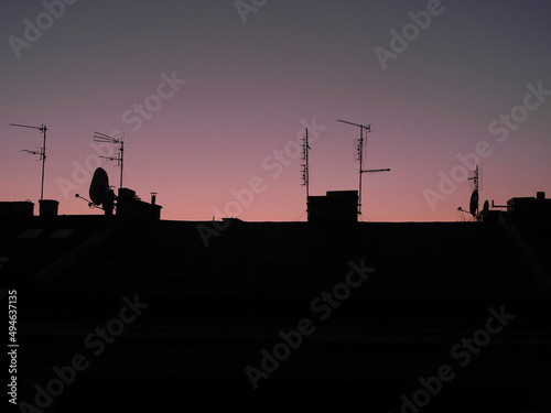 Early morning view from attic: rooftops silhouette at dusk until sunrise 