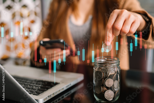 Female hand puting coins in glass for saving money. concept finance and accounting in the home.