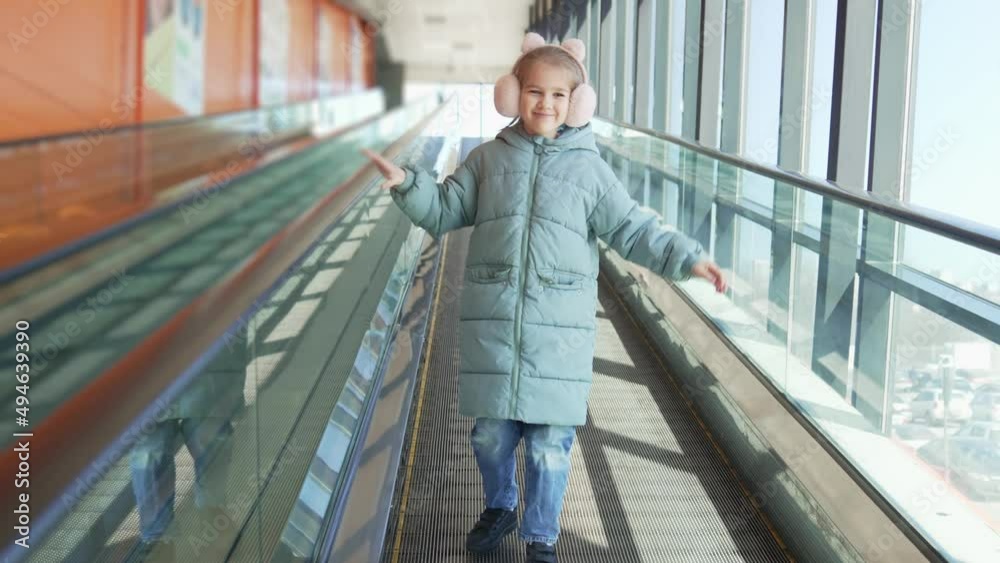 a little girl goes up and calls for himself on a travolator a little girl goes up and calls for himself on a travolator