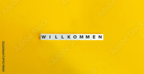 Welcome Word in German Language. Letter Tiles on Yellow Background. Minimal Aesthetics.