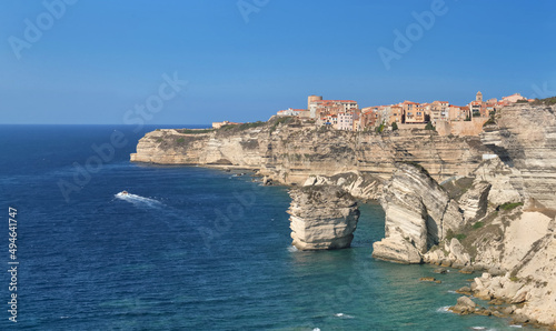 Bonifacio citadel above limestone cliff overlooking the sea on clear blue sky- corsica