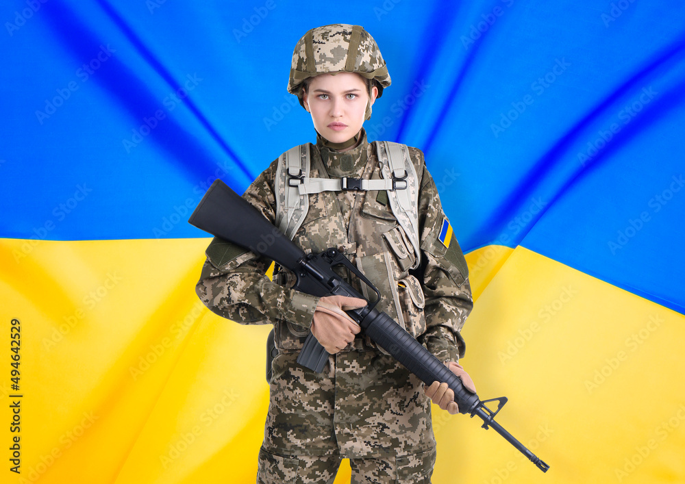 Fototapeta premium Armed soldier in military camouflage uniform and Ukrainian flag on background. Stop war
