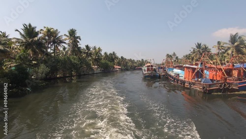 Fishing boats moored on banks of navigable canal at Alappuzha or Alleppey, India. Backward shot