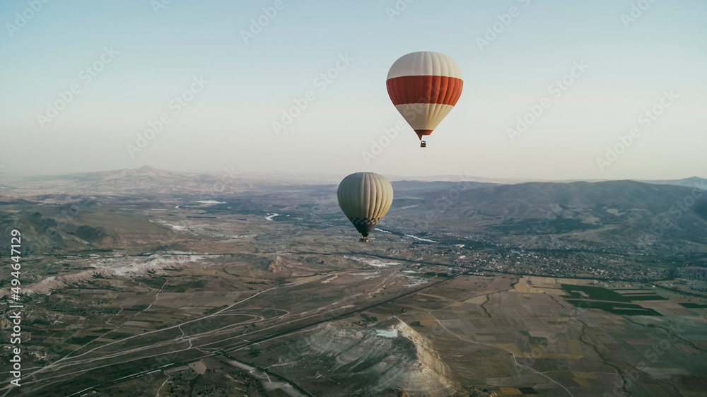 Hot air balloon flying above rocky landscape.