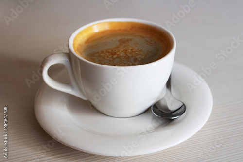 White cup with coffee on the table