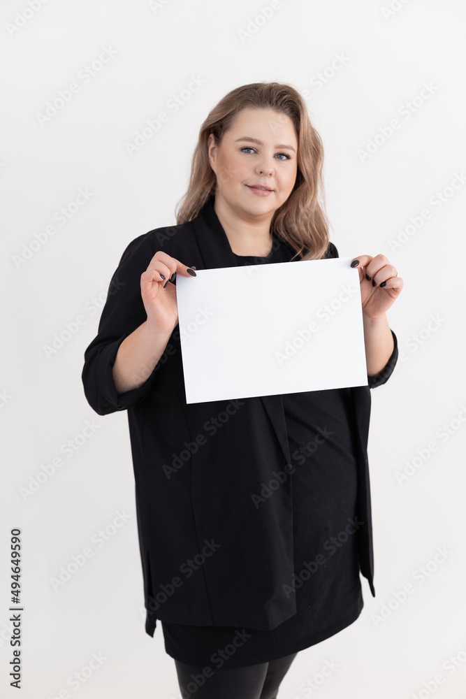 Smiling beauteous middle-aged fat plus-size overweight plump woman with make-up holding blank white sheet of paper. Smiling beauteous middle-aged fat plus-size overweight plump woman with make-up holding blank white sheet of paper.