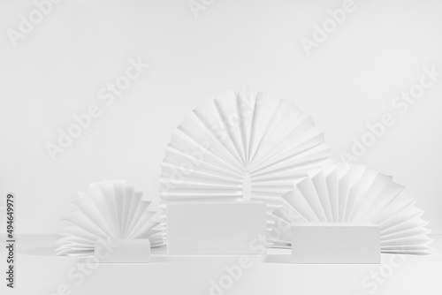 Template of three different size white podiums with soft light asian round ribbed paper fans  arch in trendy minimal style  mockup showcase for presentation cosmetic product or goods  front view.