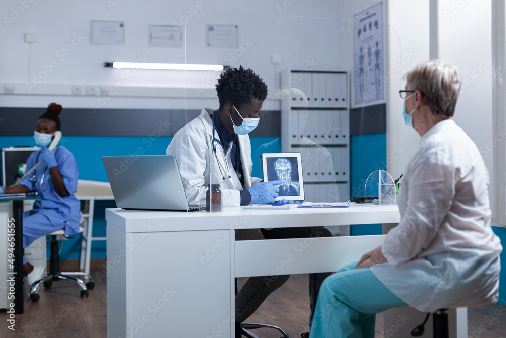 Radiology specialist explaining x-ray scan image to elderly patient in healthcare facility doctor cabinet. Radiologist talking with senior woman about scan results and consultation diagnostic. Radiology specialist explaining x-ray scan image to elderly patient in healthcare facility doctor cabinet. Radiologist talking with senior woman about scan results and consultation diagnostic.