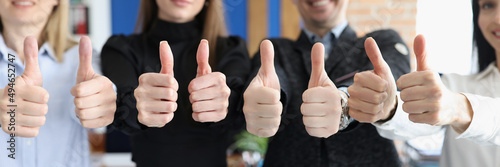 Obraz na płótnie Group of students showing thumbs up in office closeup