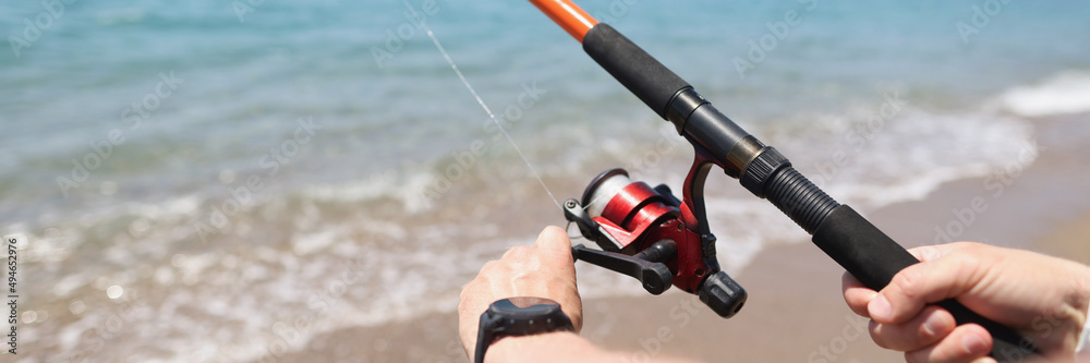 Man fishing with rod on seashore closeup Man fishing with rod on seashore closeup