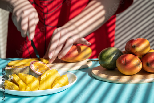 chef cutting fruits. Female hands cutting mango and passion fruit, fruit breakfast