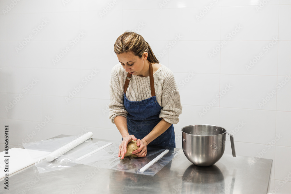 Woman kneading preparation in pastry shop in bakery Woman kneading preparation in pastry shop in bakery