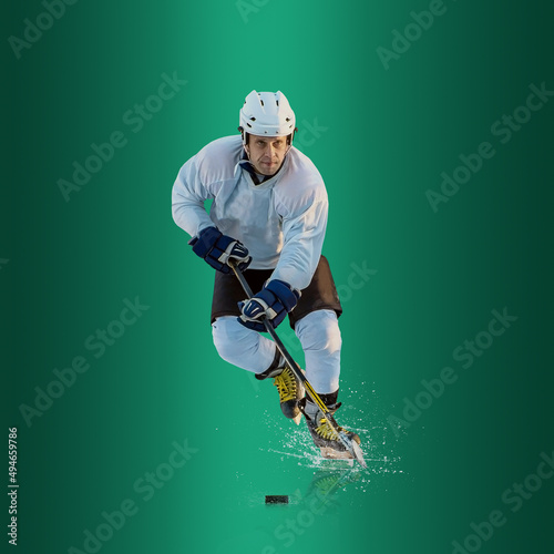 Canvas Print Professional ice hockey player hitting puck for winning goal in action on gradient multicolored neon background