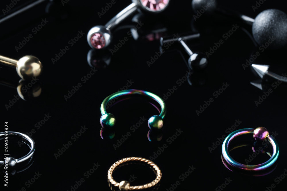 Stylish jewelry for piercing on black background - obrazy, fototapety, plakaty 