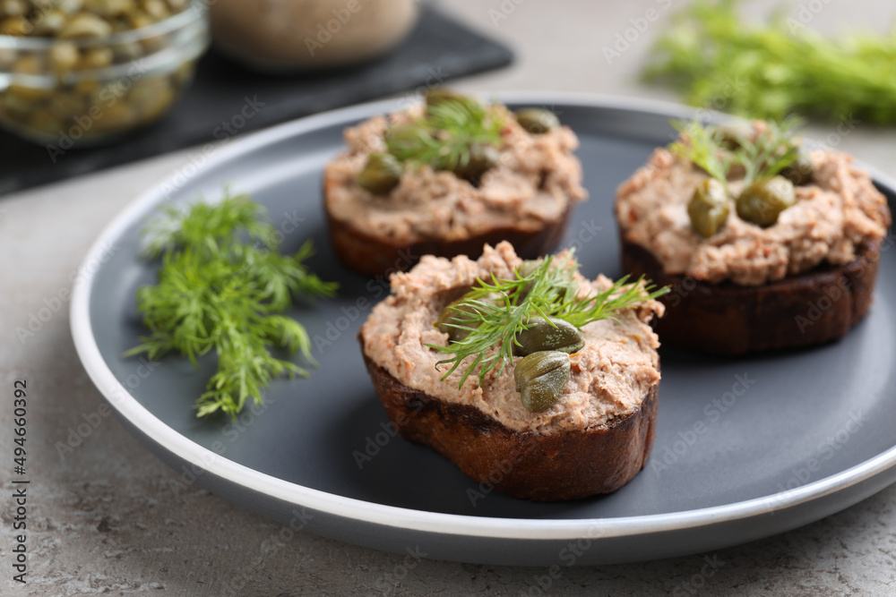 Slices of bread with delicious pate, capers and dill on light grey table, closeup Slices of bread with delicious pate, capers and dill on light grey table, closeup