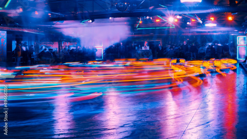 Illuminated lights of bumper cars at a funfair at night with abstract motion blur due to long time exposure
