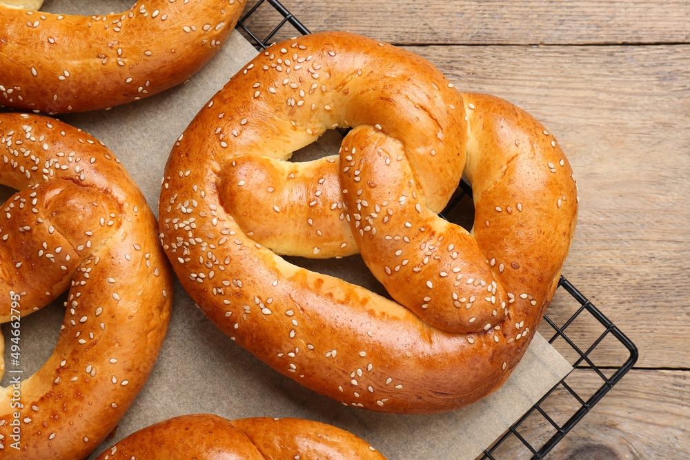Cooling rack with delicious freshly baked pretzels on wooden table, top view Cooling rack with delicious freshly baked pretzels on wooden table, top view
