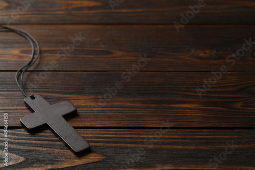 Wooden Christian cross on table, space for text