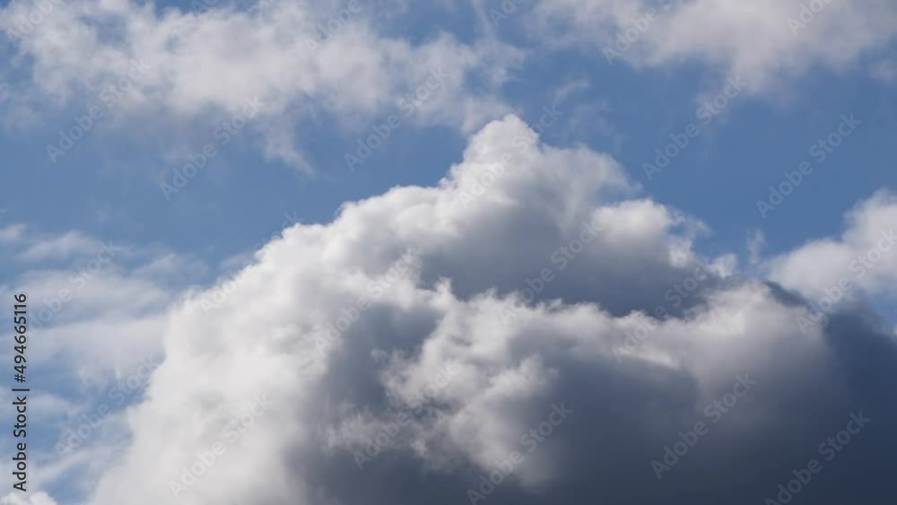 Fluffy white slow clouds moving across blue sky Fluffy white slow clouds moving across blue sky