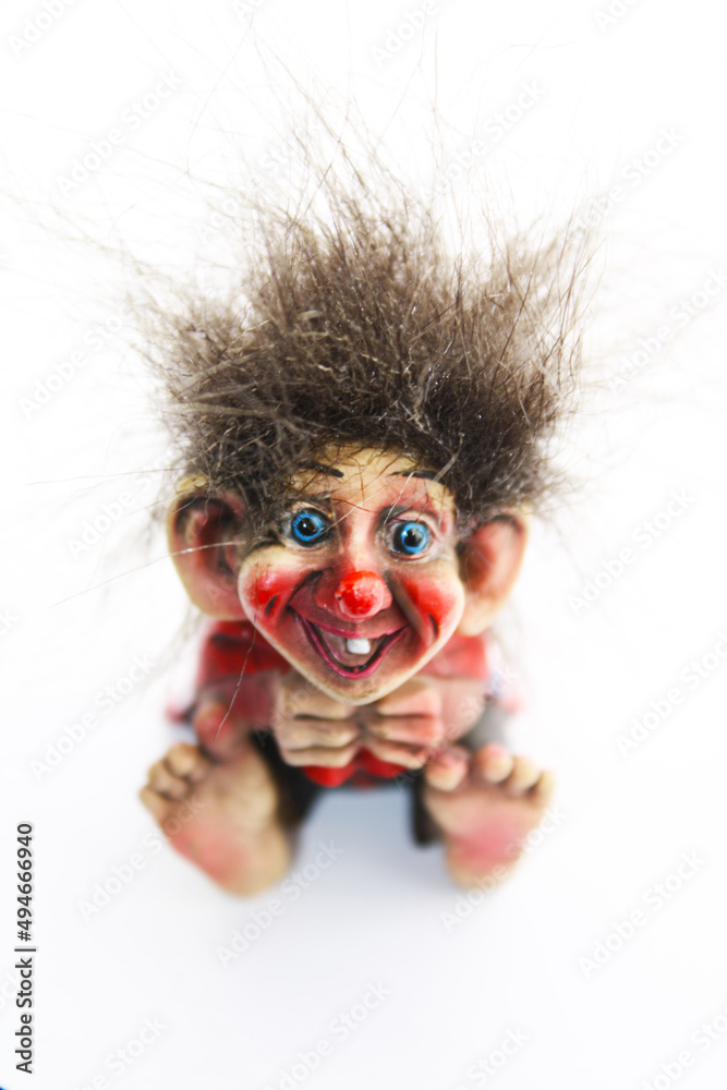 Obraz premium Little cute funny colorful norwegian troll figurine on a white background.