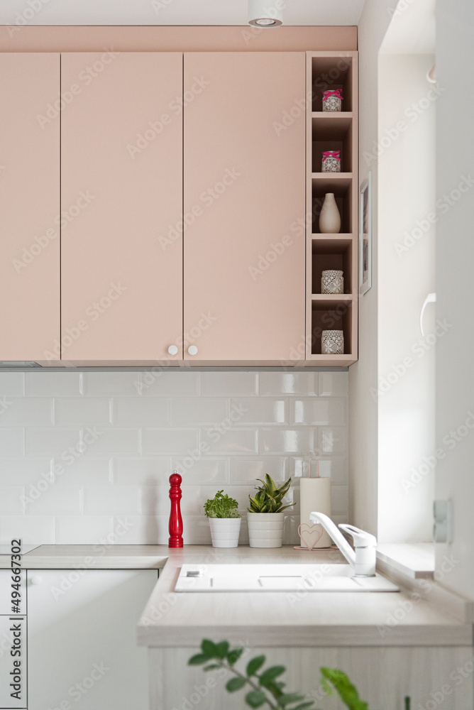 Detal w kuchni w minimalistycznym nowoczesnym stylu. Białe i różowe fronty mebli oraz sprzęt. - obrazy, fototapety, plakaty 