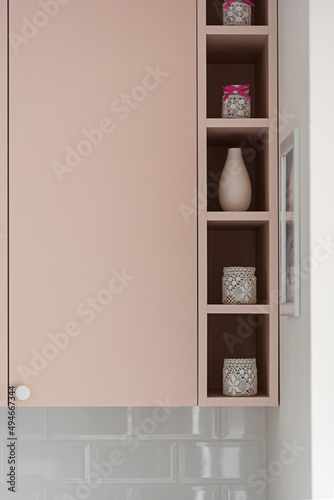 Detal w kuchni w minimalistycznym nowoczesnym stylu. Białe i różowe fronty mebli oraz sprzęt.