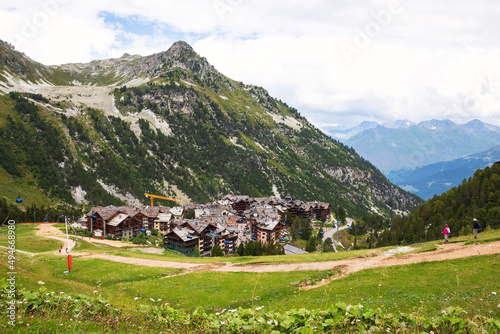 Senior couple hiking at French Alps near Arcs 2000 ski station. Summer in Savoie, France. Mountain summer resort vacation background. Healthy active lifestyle, elderly wellness concepts. photo