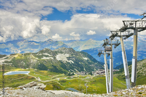 Alpine view and cable car near Arcs 2000 ski station in Savoie, France. Mountain summer resort vacation background. Healthy lifestyle, active family holidays concept. 