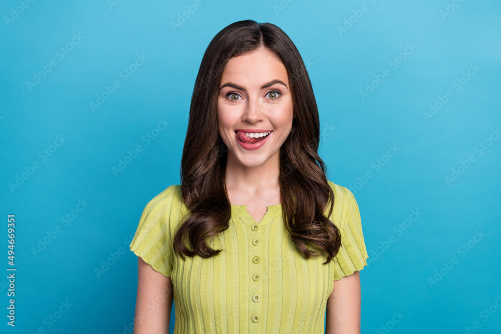 Fototapeta premium Photo of cute young brunette lady lick lip wear green t-shirt isolated on blue color background